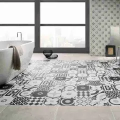 Bagno moderno con vasca freestanding e pavimento decorato con cementine in bianco e nero, che creano un effetto visivo unico.