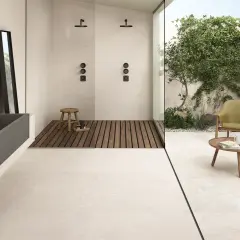 Pavimento casa al mare con vasca in pietra, doccia esterna e zona relax con poltrone.