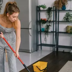 Donna pulisce il pavimento con uno straccio, mostrando come pulire un pavimento poroso.
