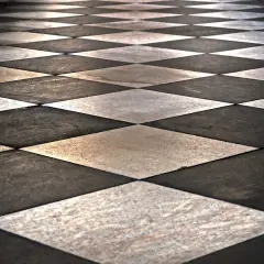 Pavimento a scacchi con posa piastrelle in diagonale, alternando marmo bianco e nero.