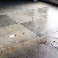 Pavimento in gres rovinato, con macchie e crepe. Un'immagine che mostra la necessità di sbiancare pavimento gres per un restauro.