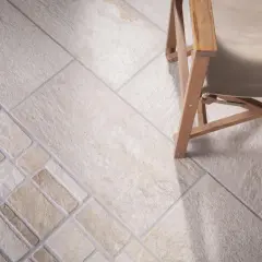 Schemi di posa piastrelle 30x60 con inserti decorativi e una sedia in legno.