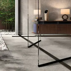 Un elegante soggiorno con arredi moderni e un giardino zen con bambù, evocando la raffinatezza del cotto d'Este.