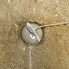 Dettaglio di un foro in muratura con un inserto in tessuto e un tubo, forse per il drenaggio o per i diatoni muratura.