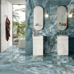 Bagno di lusso con pavimenti e pareti in diversi tipi di gres porcellanato effetto marmo blu e bianco.