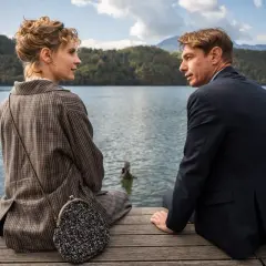 Coppia seduta su un pontile, con uno sguardo intenso. Nonostante i **wpc difetti** visibili, la scena evoca un'atmosfera di profonda connessione.