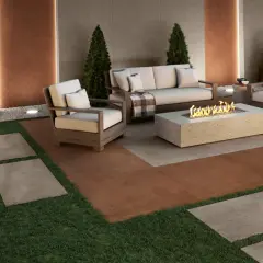 Elegante soggiorno esterno con divano, poltrone e tavolino con fuoco. Il pavimento per balcone in gres porcellanato effetto pietra crea un'atmosfera accogliente.