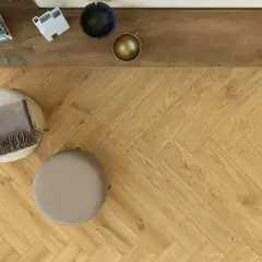 Posa pavimento gres effetto legno a spina di pesce, con pouf e coperta.