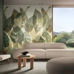 Soggiorno con divano beige e poltrone in legno, parete con fap rivestimenti a tema foglie tropicali e vista su giardino lussureggiante.