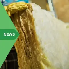Mano con guanto giallo tiene isolante. Attenzione: la lana di vetro fa male se non maneggiata con cura.