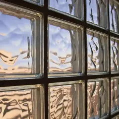 Muro di vetrocemento con riflessi del cielo. Lo spessore del vetrocemento crea un effetto ondulato.