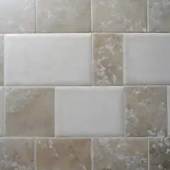 Pareti con piastrelle rettificate e fuga minima. Diverse tonalità di beige e bianco creano un motivo moderno e pulito.