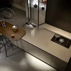 Un'elegante cucina moderna con isola centrale in acciaio spazzolato, piano a induzione e un'area snack in legno. Perfetta per chi ama lappare in cucina con stile.