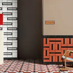 Un soggiorno moderno con pavimenti geometrici. Una poltrona a dondolo blu e legno, un piedistallo con una lampada rossa e una teiera blu.