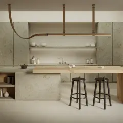 Cucina moderna con isola in legno e piano in gres porcellanato. Due sgabelli scuri completano l'arredo.