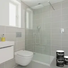 Bagno moderno con doccia, lavabo e WC. Due barattoli di pittura piastrelle bagno "Emottion" sono posizionati vicino alla doccia.
