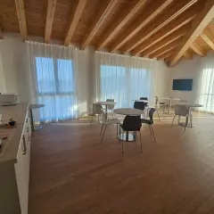 Pavimento per mansarda in legno chiaro, con travi a vista e arredi moderni.