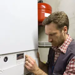 Tecnico che regola una caldaia. Guida alla scelta della caldaia ideale per la tua casa.