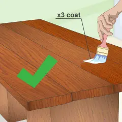 Mano che applica una mano di vernice trasparente per impermeabilizzare il legno fai da te. Tre mani consigliate per una protezione ottimale.