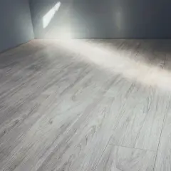 Pavimento in gres porcellanato effetto legno grigio, con luce che filtra dall'alto. Ideale per pulire fughe gres porcellanato effetto legno.
