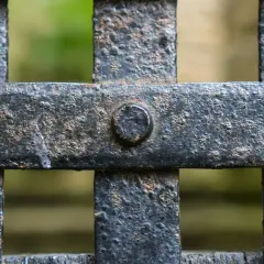 Dettaglio di una grata in ferro arrugginito, con bulloni visibili. Pronto per verniciare ferro arrugginito e riportarlo al suo antico splendore.