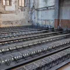 Strutture metalliche a traliccio pronte per essere posizionate per come rinforzare un solaio da sotto. L'ambiente è in fase di ristrutturazione.