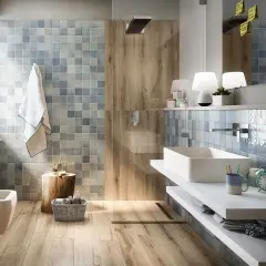 Bagno rustico contemporaneo con piastrelle azzurre e inserti in legno. Lavabo rettangolare, bidet e doccia a vista.