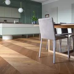 Un elegante soggiorno con cucina moderna e un **miglior parquet** a spina di pesce, che crea un gioco di luci e ombre.