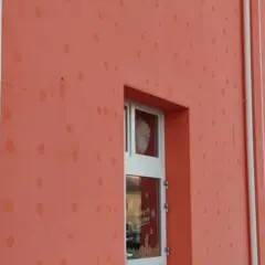 Muri esterni color salmone con macchie sul cappotto esterno, forse residui di pioggia o decorazioni.