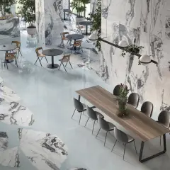 Un elegante spazio con pavimenti e pareti in marmo, tavoli e sedie moderne. Il **significato lappato** si riflette nella finitura liscia e lucida delle superfici.