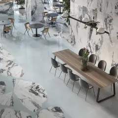 Interni eleganti con pavimenti e pareti che richiamano i **marmo di Carrara colori** con venature grigie e bianche, tavoli e sedie moderne.
