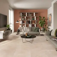 Soggiorno moderno con divani grigi, libreria e un elegante pavimento effetto cemento abbinamento perfetto con l'arredo.