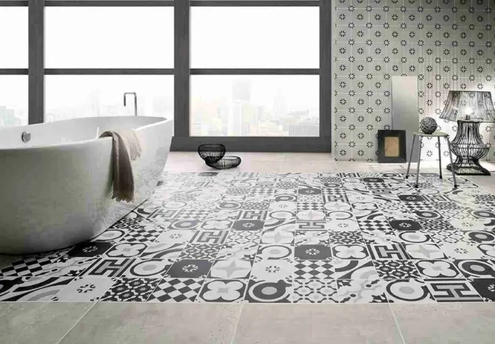 Bagno moderno con vasca freestanding e pavimento decorato con cementine in bianco e nero, che creano un effetto visivo unico.