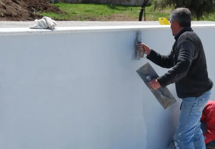Operaio stende malta bastarda su un muro. Questo materiale serve per intonaci e murature, garantendo resistenza e durabilità.