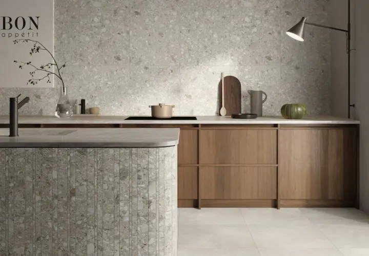 Cucina moderna con isola in **ceppo di gre** e rivestimenti a parete in grès effetto terrazzo.