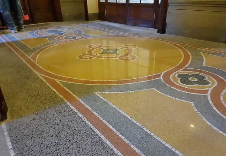 Pavimento in graniglia con motivi geometrici e floreali, un classico pavimento anni 50 che dona un tocco di eleganza retrò.