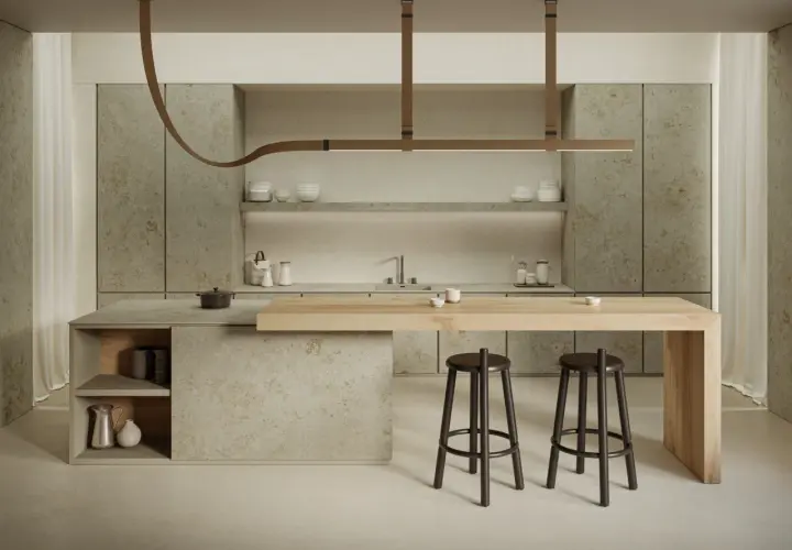 Cucina moderna con isola in legno e piano in gres porcellanato. Due sgabelli scuri completano l'arredo.