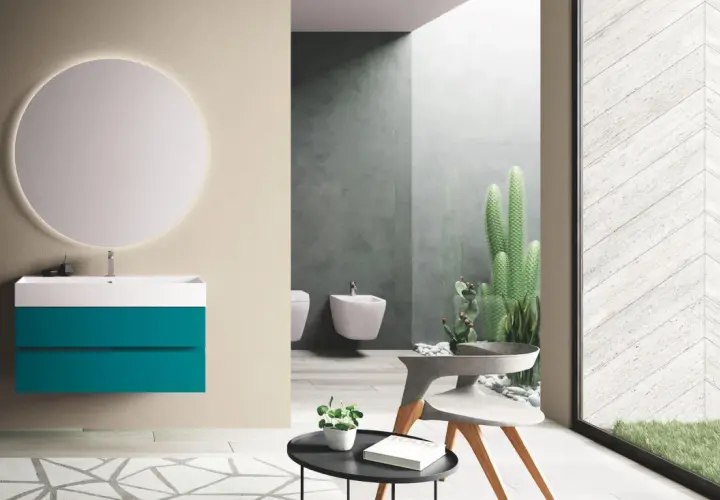 Bagno moderno con mobile sospeso turchese, specchio luminoso e cactus. Le puntotre arredobagno recensioni confermano l'eleganza.