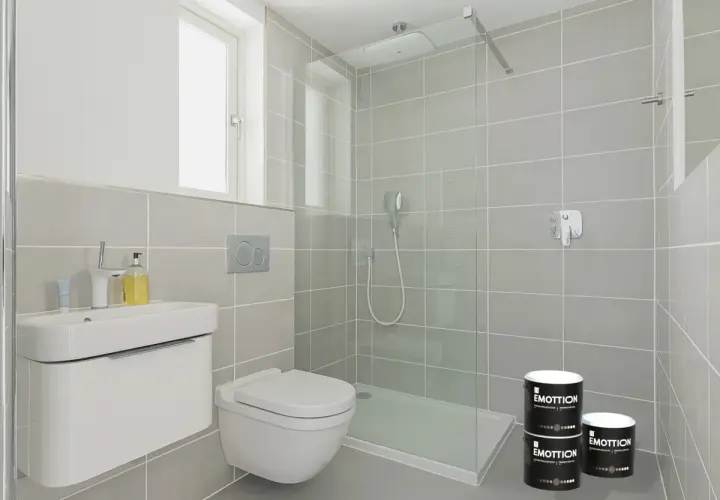 Bagno moderno con doccia, lavabo e WC. Due barattoli di pittura piastrelle bagno "Emottion" sono posizionati vicino alla doccia.