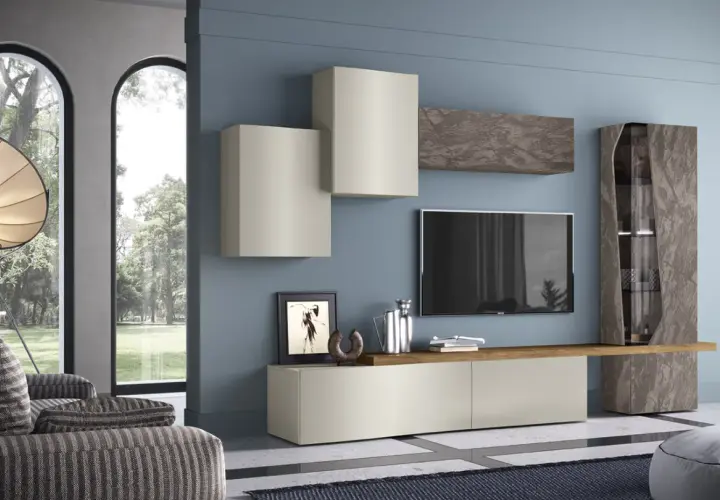 Soggiorno con pareti blu polvere e mobili scuri effetto pietra. Un mobile basso, pensili chiari e una vetrina alta creano un'elegante composizione.