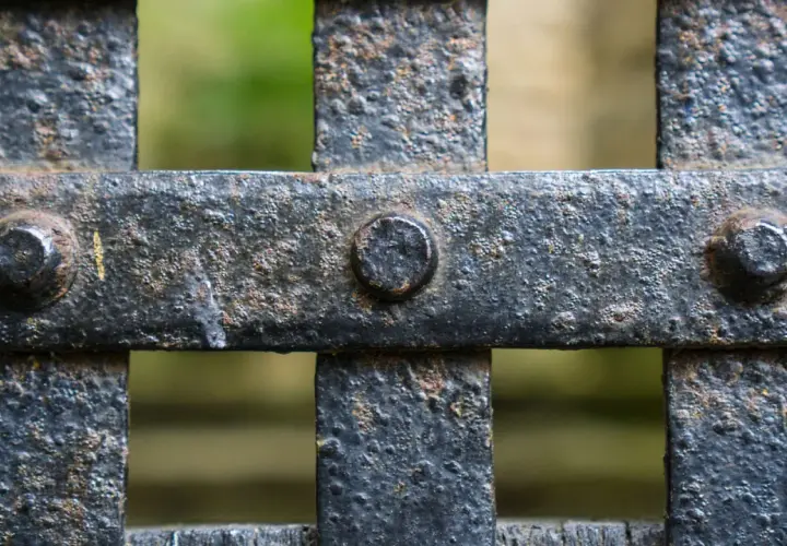 Dettaglio di una grata in ferro arrugginito, con bulloni visibili. Pronto per verniciare ferro arrugginito e riportarlo al suo antico splendore.