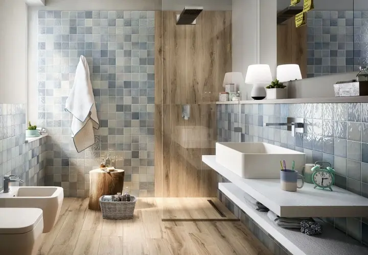 Bagno rustico contemporaneo con piastrelle azzurre e inserti in legno. Lavabo rettangolare, bidet e doccia a vista.