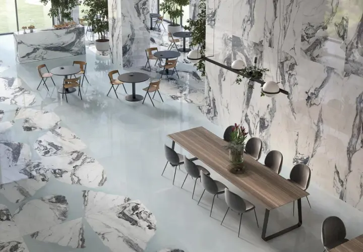 Un elegante spazio con pavimenti e pareti in marmo, tavoli e sedie moderne. Il **significato lappato** si riflette nella finitura liscia e lucida delle superfici.
