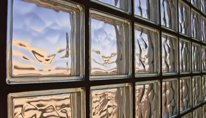 Muro di vetrocemento con riflessi del cielo. Lo spessore del vetrocemento crea un effetto ondulato.
