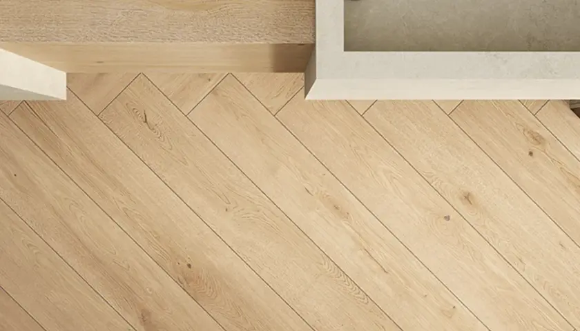 Pavimento in gres effetto legno posato a spina di pesce. Le fughe sottili e scure risaltano il colore naturale del legno, creando un effetto caldo e accogliente.
