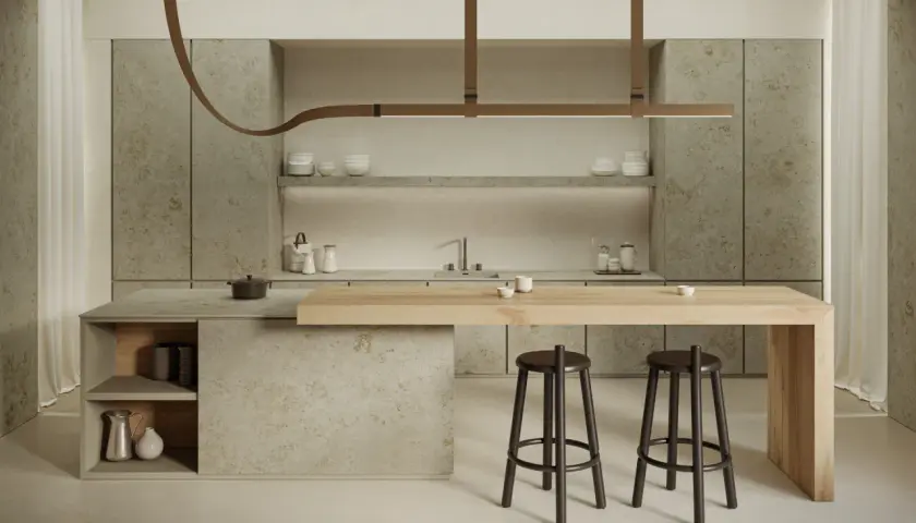 Cucina moderna con isola in legno e piano in gres porcellanato. Due sgabelli scuri completano l'arredo.