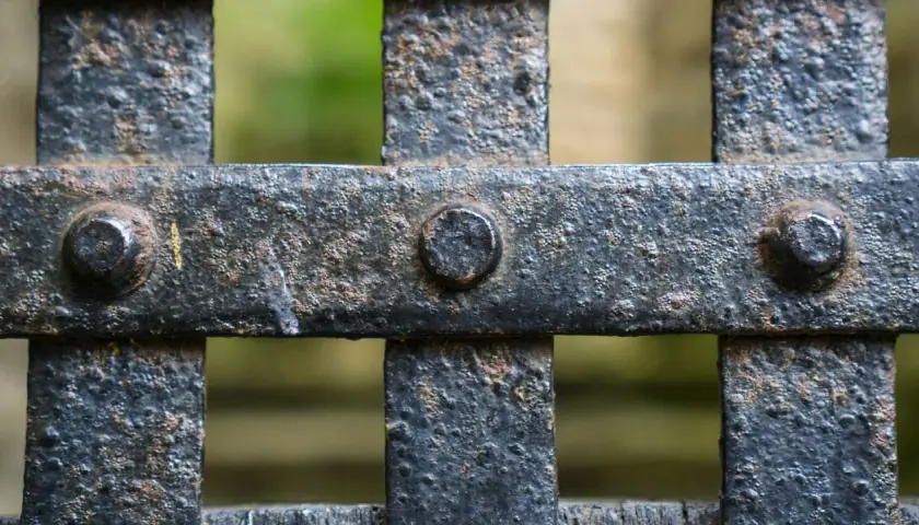 Dettaglio di una grata in ferro arrugginito, con bulloni visibili. Pronto per verniciare ferro arrugginito e riportarlo al suo antico splendore.