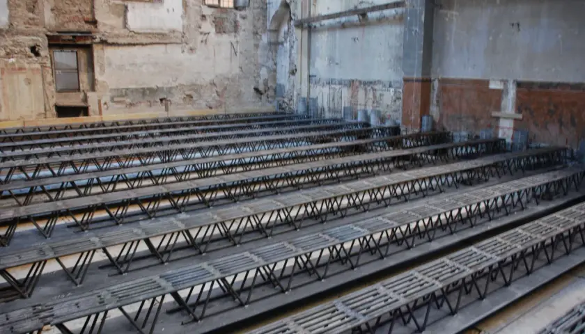 Strutture metalliche a traliccio pronte per essere posizionate per come rinforzare un solaio da sotto. L'ambiente è in fase di ristrutturazione.