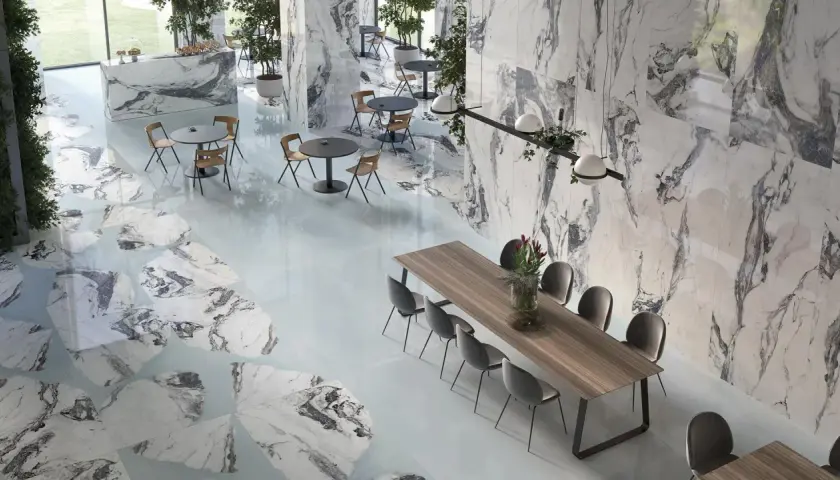 Un elegante spazio con pavimenti e pareti in marmo, tavoli e sedie moderne. Il **significato lappato** si riflette nella finitura liscia e lucida delle superfici.