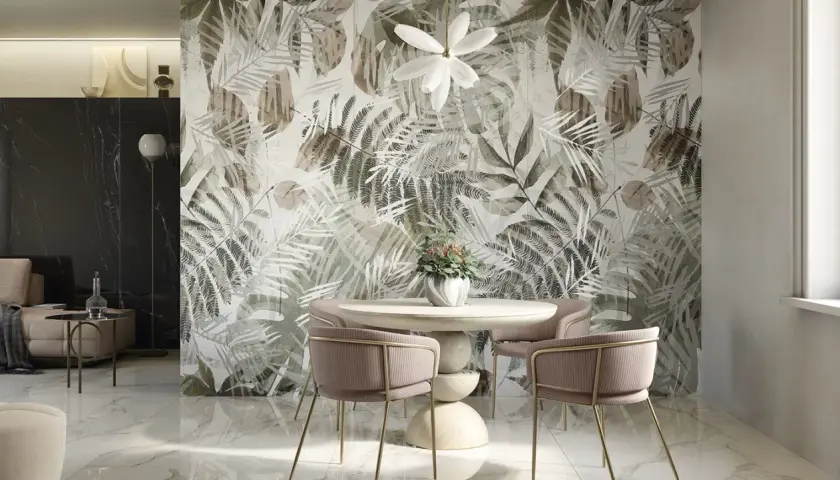 Un tavolo rotondo con sedie rosa e un vaso di fiori davanti a una parete con un motivo botanico. Idee originali per decorare una parete con un tocco tropicale.